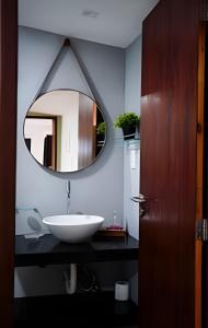 Un baño con un lavabo blanco y un espejo. en Flat Superior com Vista Panorâmica e Piscina Compartilhada, en Fernando de Noronha