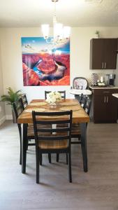 a dining room table with chairs and a painting on the wall at Red Rock Retreat Your Home Away From Home in Kanab
