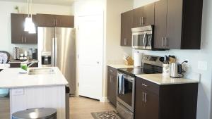 a kitchen with brown cabinets and a stainless steel refrigerator at Red Rock Retreat Your Home Away From Home in Kanab