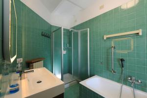 a green tiled bathroom with a sink and a shower at Luxury Panoramic Apt w Garage Happy Home Bergamo 2 in Bergamo +55 photos