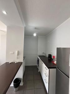 a kitchen with white walls and a black counter top at Departamento equipado 203 Ovalle in Ovalle