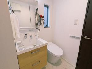 横浜市にあるHan Homes Yokohamaの洗面台、トイレ、鏡のあるバスルーム