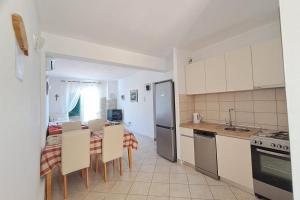 eine Küche mit Tisch und Stühlen und einem Kühlschrank in der Unterkunft Family-friendly apartments with swimming pool Povlja, Brac - 24248 in Povlja