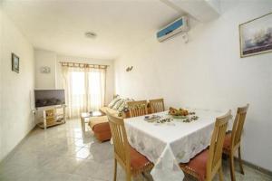 ein Esszimmer mit Tisch und Stühlen und einem Fernseher in der Unterkunft Family-friendly apartments with swimming pool Povlja, Brac - 24248 in Povlja