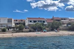 eine Gruppe von Menschen an einem Strand in der Nähe des Wassers in der Unterkunft Family-friendly apartments with swimming pool Povlja, Brac - 24248 in Povlja