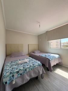 a bedroom with two beds and a window at Departamento equipado 206B Ovalle in Ovalle