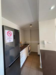 a kitchen with a no smoking sign on a refrigerator at Departamento equipado 206B Ovalle in Ovalle
