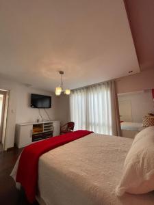 a bedroom with a bed and a flat screen tv at Casa dos Vinhedos, Conforto, Lazer e Eventos em Bento Gonçalves in Bento Gonçalves