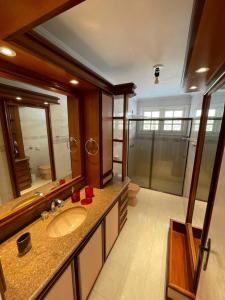a bathroom with a sink and a large mirror at Casa dos Vinhedos, Conforto, Lazer e Eventos em Bento Gonçalves in Bento Gonçalves
