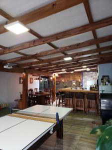 a ping pong table in a room with tables and chairs at Casa dos Vinhedos, Conforto, Lazer e Eventos em Bento Gonçalves in Bento Gonçalves