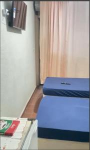 une chambre avec un lit bleu et une table avec un livre dans l'établissement Refúgio 3rd, à Piraí 1 autre photo