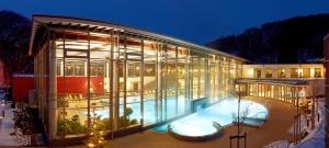 a large glass building with a swimming pool at night at Landhaus Bad Bertrich in Bad Bertrich