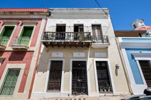 a building with a balcony in a city at Old San Juan Art Loft Fast Wifi Near El Morro in San Juan