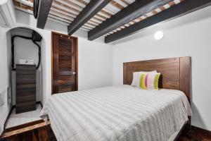 a bedroom with a large bed with a wooden headboard at Old San Juan Art Loft Fast Wifi Near El Morro in San Juan