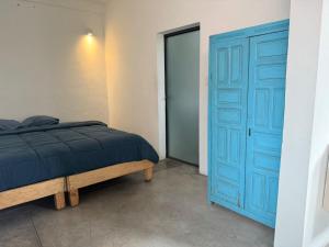 a bedroom with a blue door and a bed at Casa Hoja Azul in San Miguel de Allende
