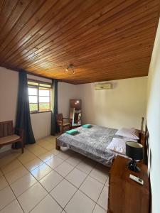 a bedroom with a bed and a wooden ceiling at Luna's Home Raiatea 