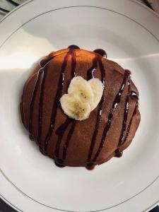 a piece of chocolate dessert with a banana on a plate at Raya Homestay in Kuta Lombok