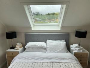 a bedroom with a bed with a window above it at Hot Tub and Views in Castle Hill