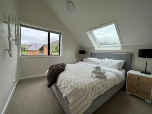 a bedroom with a large bed with two windows at Hot Tub and Views in Castle Hill +16 photos