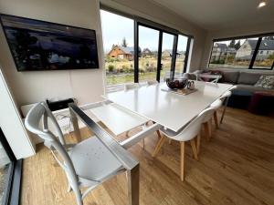 a white dining table and chairs in a living room at Hot Tub and Views in Castle Hill