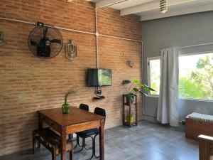 a dining room with a table and a television at Terrazas del Pinar, Loft en bosque serrano in Villa Ciudad de America