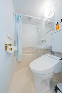 a white bathroom with a toilet and a sink at Extreme in Sapporo