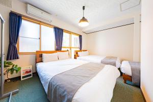 two beds in a room with two windows at Extreme in Sapporo