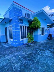 a blue house with a motorcycle parked in front of it at Gensan Staycation up to 20pax in Lagao III +4 photos