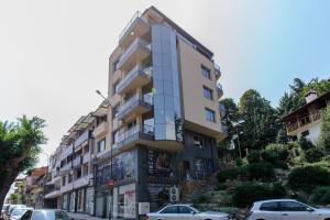 a tall building with cars parked in front of it at Sandanski Peak Guest Rooms in Sandanski