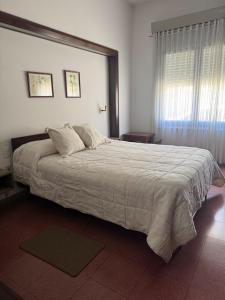 Un dormitorio con una cama grande y una ventana. en La Casona, en Alta Gracia