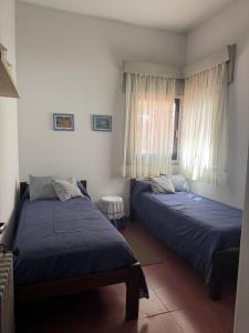Un dormitorio con dos camas y una ventana. en La Casona, en Alta Gracia 4 fotos más