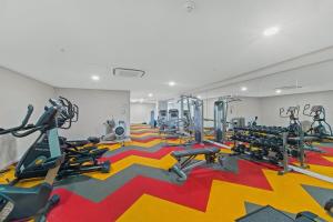 une salle de sport avec plusieurs machines de course sur un tapis coloré dans l'établissement Luxe Sydney Olympic Park Stay - 2BR for 4 Guest, à Sydney