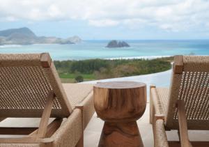 セロング・ベラナクにあるSABA Lombokの海の景色を望む椅子2脚とテーブル