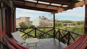 a porch with two chairs and a hammock at Crema y Frutilla Chapadmalal in Chapadmalal