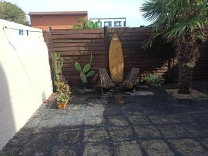 a privacy fence with two benches and a surfboard at Chalet Faro in Mar del Plata +5 photos