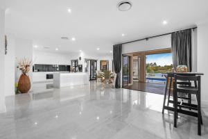 ゴールドコーストにあるSerene 5BR Waterfront Escape - Prestigeのテーブルと椅子のあるキッチンとリビングルーム