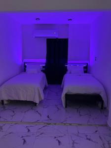 2 Betten in einem Zimmer mit lila Beleuchtung in der Unterkunft 3D Bless Apartment 4 min from the airport and beach in San Juan + 5 Fotos