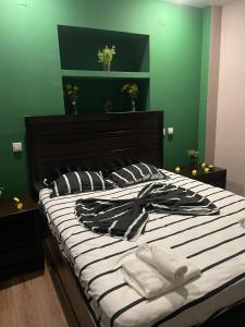 a bedroom with a large bed with green walls at 1 bdrm apt with jacuzzi in Old Town in Bucharest
