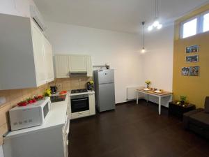 a small kitchen with a refrigerator and a table at 1 bdrm apt with jacuzzi in Old Town in Bucharest