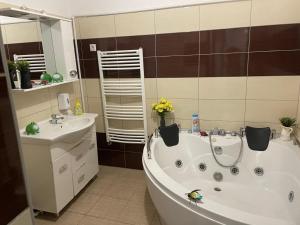 a bathroom with a bathtub and a sink and a tub at 1 bdrm apt with jacuzzi in Old Town in Bucharest