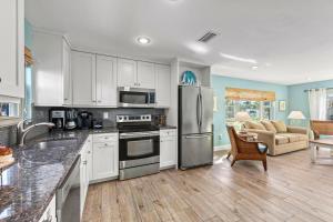 a kitchen with white cabinets and stainless steel appliances at Sand Dollar Suite - 632A in Siesta Key +37 photos