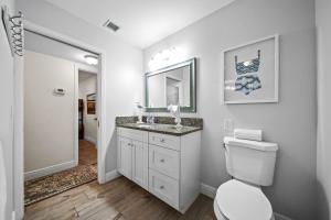 a bathroom with a toilet and a sink and a mirror at Sandcastle Suite - 632C in Siesta Key +79 photos