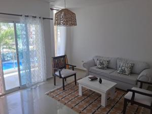 una sala de estar con un sofá y una mesa en Minutes to the beach, en Punta Cana