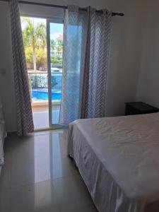 Un dormitorio con una cama y vistas a una piscina. en Minutes to the beach, en Punta Cana