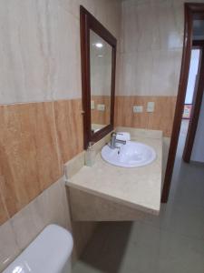 Un baño con lavabo, espejo e inodoro. en Minutes to the beach, en Punta Cana