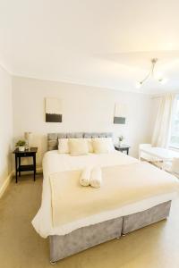 a bedroom with a large bed with two towels on it at Modern 2-Bedroom London Base - 15 mins to Central London - Next to East Croydon Station - Sleeps 5 in Croydon