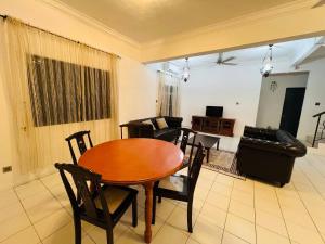Una sala de estar con una mesa y sillas de madera. en REV Homestay Taman Indah Permai, en Gua Sai