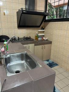una cocina con fregadero y estufa en REV Homestay Taman Indah Permai, en Gua Sai