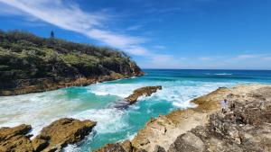 a person standing on the rocks near the ocean at Whalewatch Ocean Beach Resort in Point Lookout +152 photos