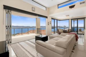 サンディ・ベイにあるThe View Luxury home 6 bed 4 bathのソファがあり海が見えるリビングルーム
